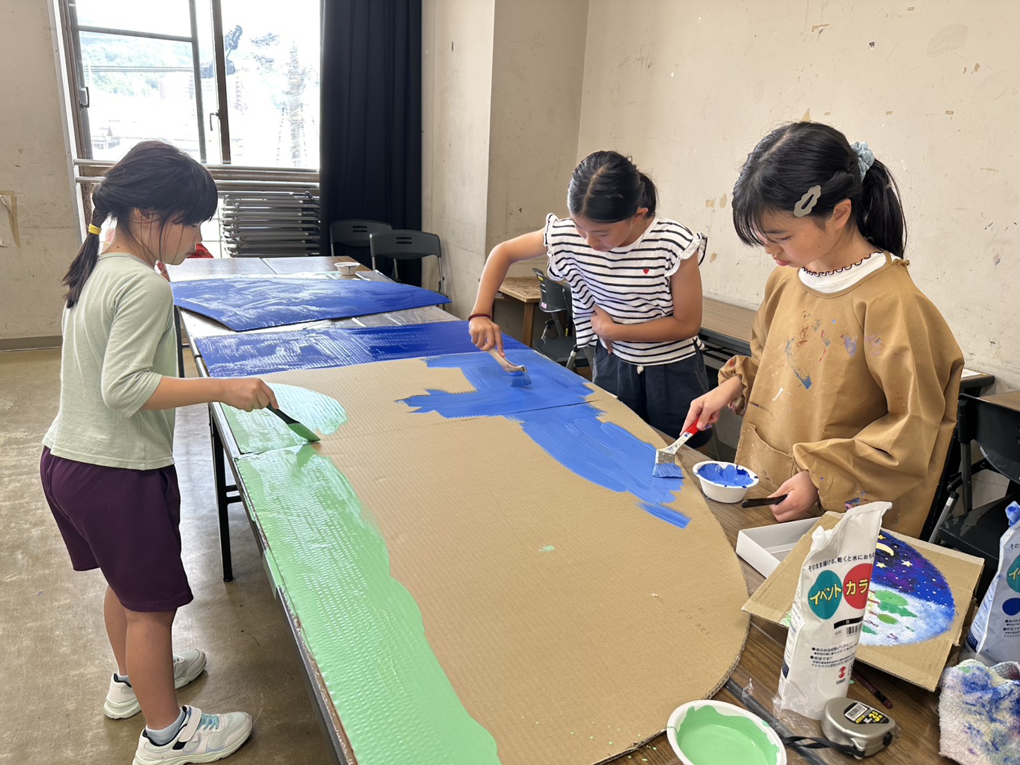 背景パネルに色を塗る子どもたち